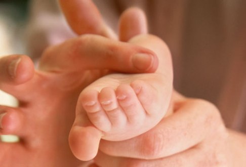 getty_rm_photo_of_mothers_hand_on_baby_foot